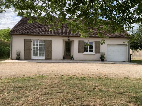 a white house with a garage at Gîte Au Cœur des Châteaux in Cheverny