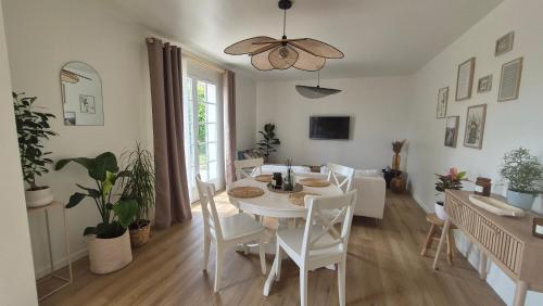a dining room with a white table and chairs at Gîte Au Cœur des Châteaux in Cheverny
