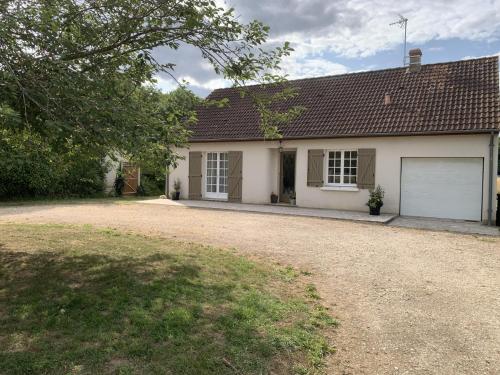 a white house with a garage and a driveway at Gîte Au Cœur des Châteaux in Cheverny
