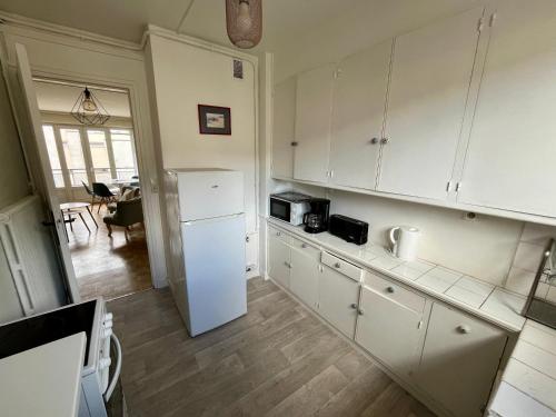 une cuisine avec des armoires blanches et un réfrigérateur blanc dans l'établissement Le spacieux Hypercentre Théâtre des Arts - 327, à Rouen