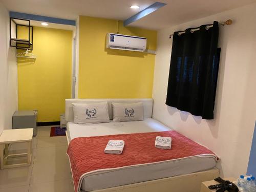 a bedroom with a bed with two towels on it at Miracle Gallery Hotel in Makkasan