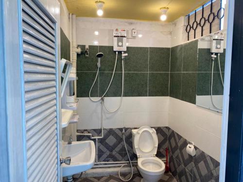 a bathroom with a toilet and a sink at Miracle Gallery Hotel in Makkasan
