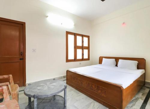 a bedroom with a bed and a table and a window at HOTEL SHREE BHAMESHWAR Near Mansa Devi Temple and Chandi Devi Temple# Ganga River - Fully Air conditioned Rooms - Best Budget Hotel in Haridwār