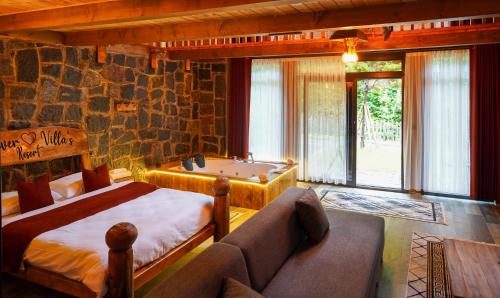 a bedroom with a bed and a tub and a couch at River Villas Resort in Çamlıhemşin