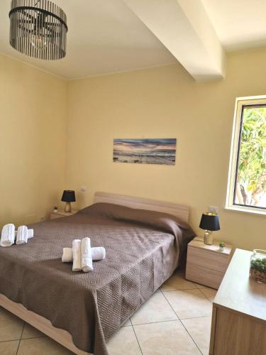 a bedroom with a bed with towels on it at Le Terre di Sicilia in SantʼAgata di Militello