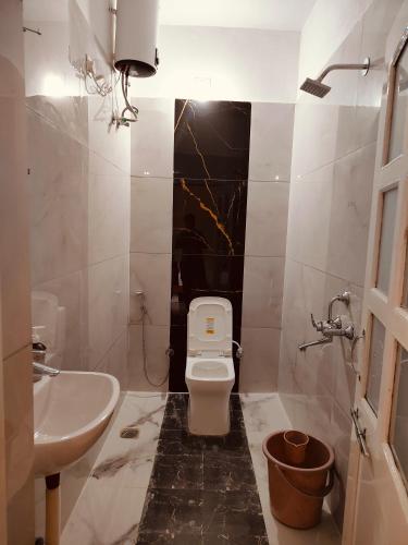 a bathroom with a white toilet and a sink at The Rajshahi Vilas in Udaipur