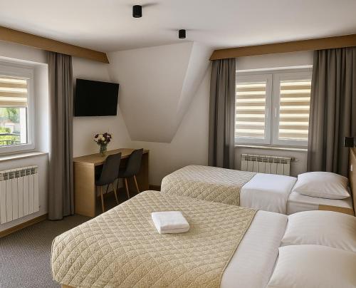 pokój hotelowy z dwoma łóżkami i biurkiem w obiekcie Willa JanDor w Zakopanem
