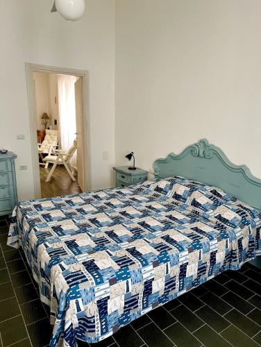 a bedroom with a bed with a blue and white quilt at Il Maestralino, nice apartment with courtyard in Calasetta