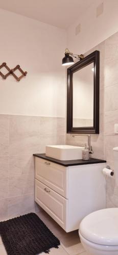 a bathroom with a white sink and a mirror at Casa vacanza in Cecina