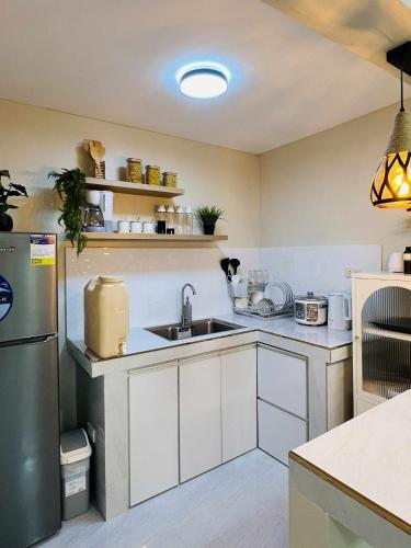 una cocina con fregadero y frigorífico en Janela's Transient, en Bantug