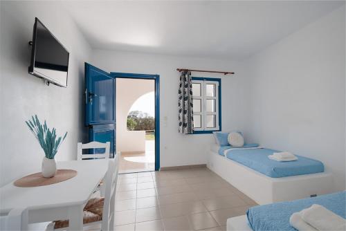 a room with a bed and a table and a television at Aurea Blu Studio 04, enjoy peace, quiet, sand and sea in Aliko Beach