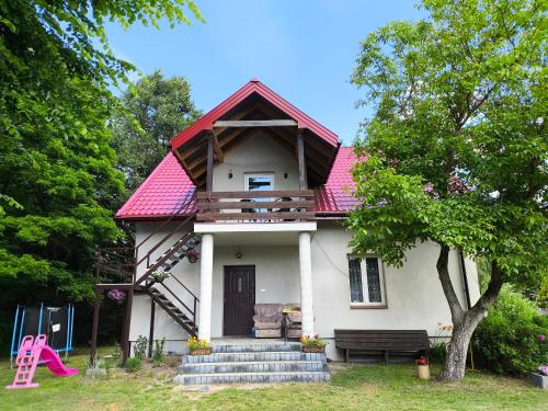 a small white house with a red roof at Agroturystyka Zacisze nad Pilicą in Stromiec