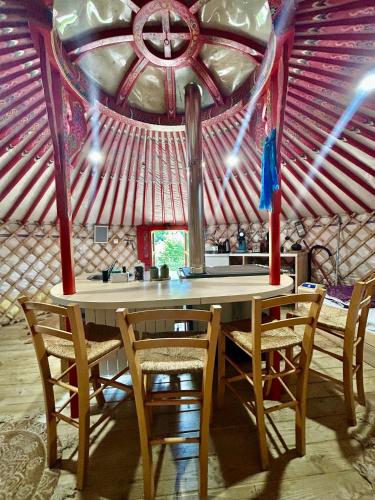 une table et des chaises dans une tente avec un plafond dans l'établissement Ravissant yourte traditionnelle, à Quimper