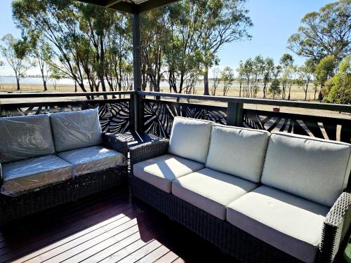 a porch with two couches on a deck at Tiny Cottage by the Lake in Waranga