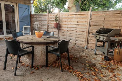 a table and chairs and a grill in a backyard at Loft SSL insolite!!! in Gignac-la-Nerthe