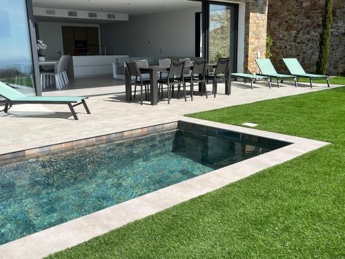 - une piscine dans une cour avec des chaises et une table dans l'établissement Villa Joya, à Rayol-Canadel-sur-Mer