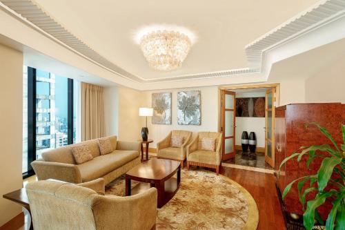 a living room with a couch and chairs and a chandelier at The Westin Dhaka in Dhaka