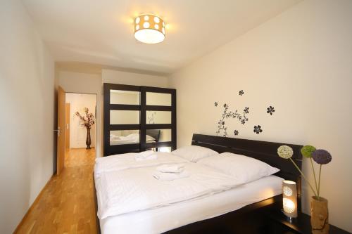 sypialnia z łóżkiem z białą pościelą i oknem w obiekcie Apartment Medvědín 331/110 w Szpindlerowym Młynie