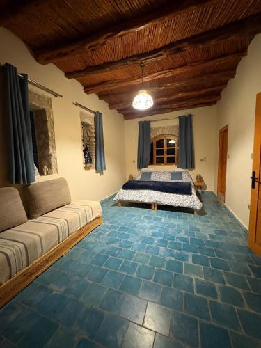 a bedroom with a bed and a couch at Villa'S in Zaouiet Bouzarktoune