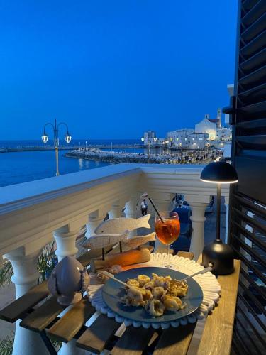 a table with a plate of food on a balcony at Aquamaris in Giovinazzo