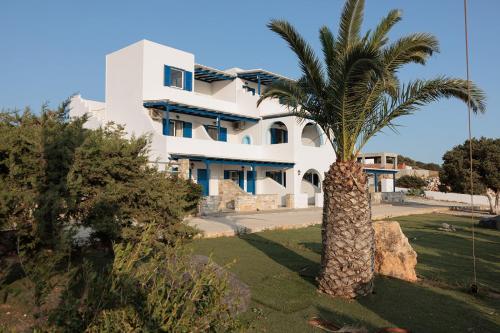 a white house with a palm tree in front of it at Aurea Blu Studio 04, enjoy peace, quiet, sand and sea in Aliko Beach