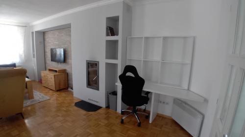una silla negra en una habitación con una pared blanca en Family home EHLI, en Vogošća