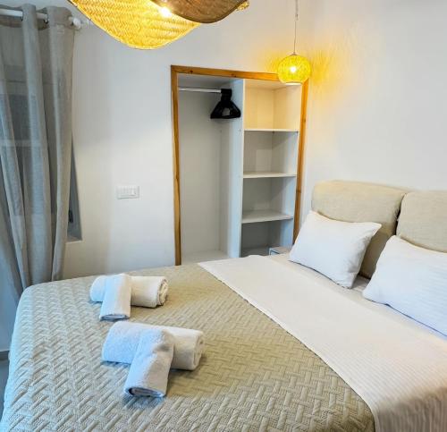 a bedroom with a large bed with towels on it at Cordiale Mykonos in Ornos