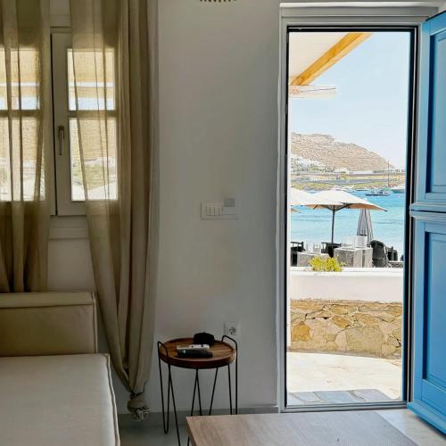a bedroom with a door open to a view of the ocean at Cordiale Mykonos in Ornos