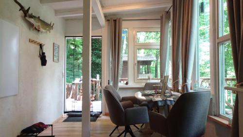 a living room with a table and chairs and windows at Ferienhaus Gädda in Vöhl