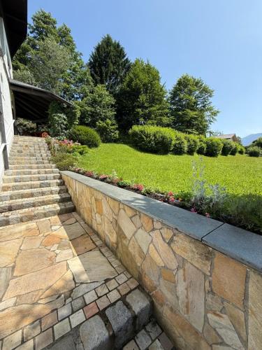 a stone retaining wall next to a garden at Die Landhausvilla in Unterach am Attersee in Unterach am Attersee