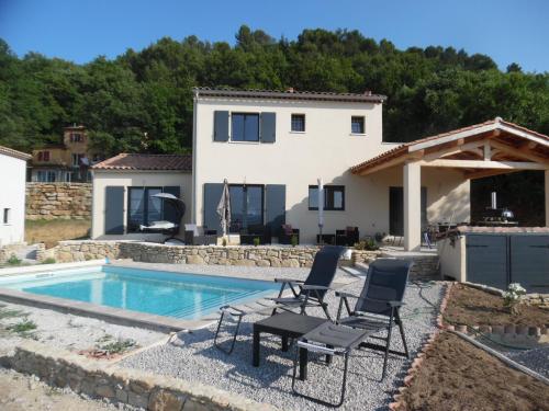 a villa with a swimming pool and two chairs and a house at Coeur de Bonnieux in Bonnieux