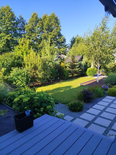 a garden with a wooden walkway and a lawn at Visit Poznan in Dąbrówka