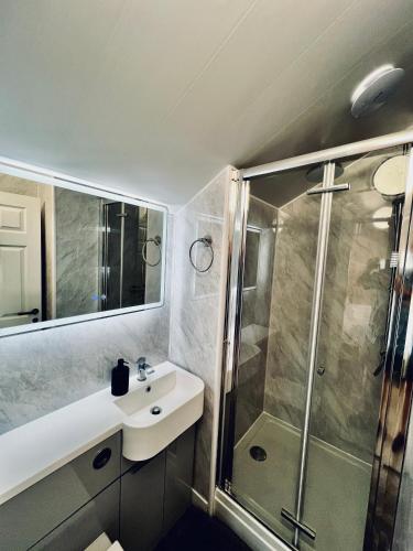 a bathroom with a sink and a shower at Saltburn Sea Front Penthouse South in Saltburn-by-the-Sea