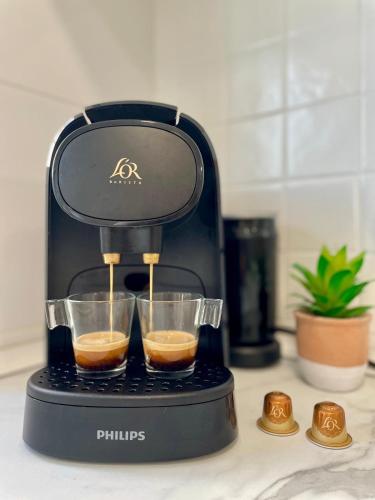 a coffee maker with two cups of coffee at La casa de la playa in Piles