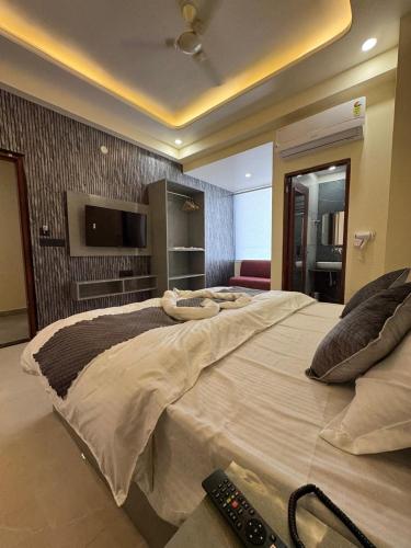 a bedroom with a large bed with a television and remote controls at Hotel Neo in Jaipur