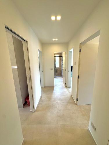 an empty hallway with white walls and floors and doors at Family apartment in Rapallo