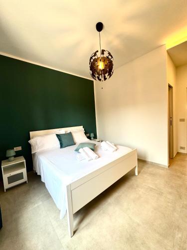a bedroom with a white bed and a green wall at Family apartment in Rapallo