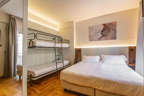 a bedroom with a bed and two bunk beds at Madi city Hotel in LʼAquila