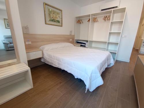 una camera con letto bianco e scaffali di Apartamentos BONDELA a Madrid