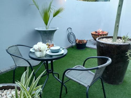 a patio with a table and chairs and plants at 9 on Meul in Prince Alfreds Hamlet