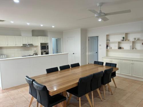 a kitchen and dining room with a wooden table and chairs at Holiday fun mildura family retreat in Mildura