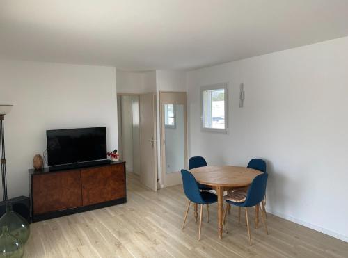 un salon avec une table en bois et une télévision dans l'établissement Appartement grande terrasse à 1 min de la plage, à Carnon-Plage