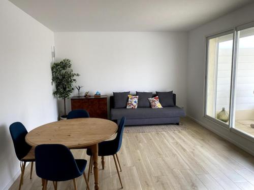 un salon avec une table et un canapé dans l'établissement Appartement grande terrasse à 1 min de la plage, à Carnon-Plage
