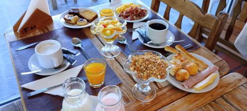 a table with breakfast foods and drinks on it at La Posada De Madryn in Puerto Madryn