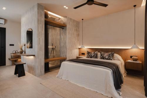 a bedroom with a large bed and a ceiling fan at Emery Hotel in Naxos Chora