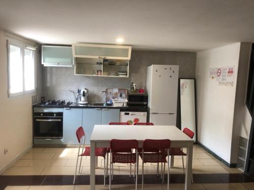 une cuisine avec une table, des chaises et un réfrigérateur dans l'établissement Maison POUR OUVRIERS seulement PAS DE TOURISME, NI FAMILLE, à Stains