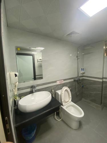 a bathroom with a toilet and a sink and a mirror at MAI VANG Hotel in Sapa