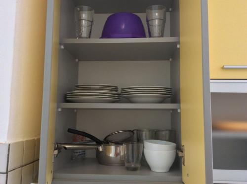 a cupboard with plates and other dishes in it at Budva Old City Central Studio Private in Budva