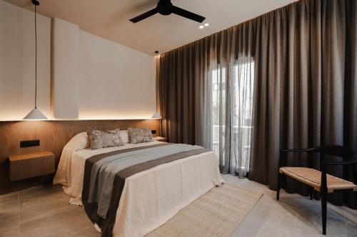 a bedroom with a bed and a ceiling fan at Emery Hotel in Naxos Chora