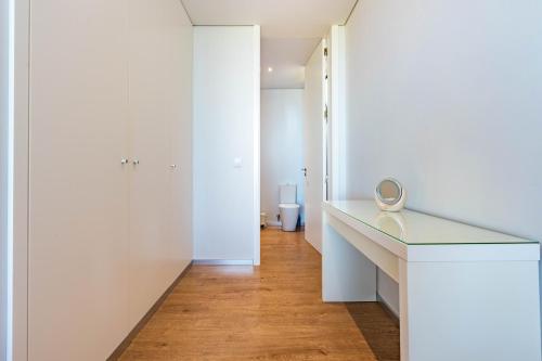 Baño blanco con escritorio y espejo en Villa Pinheira III heated pool, en Calheta